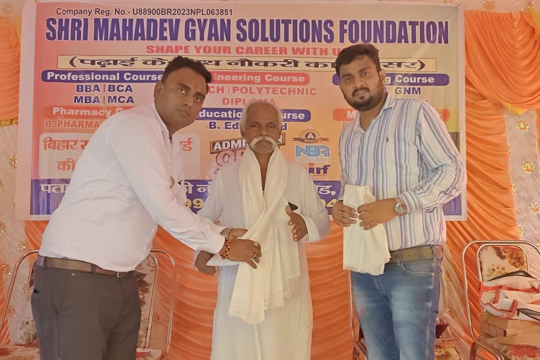A senior guest felicitated at a Foundation programme, with the banner listing the courses offered