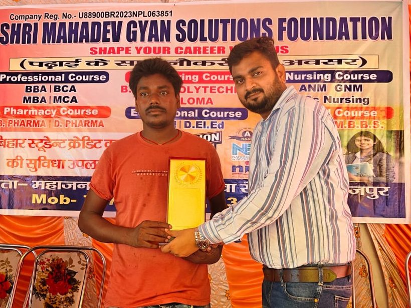 A student receiving a momento from the Foundation team at a programme in Bihar